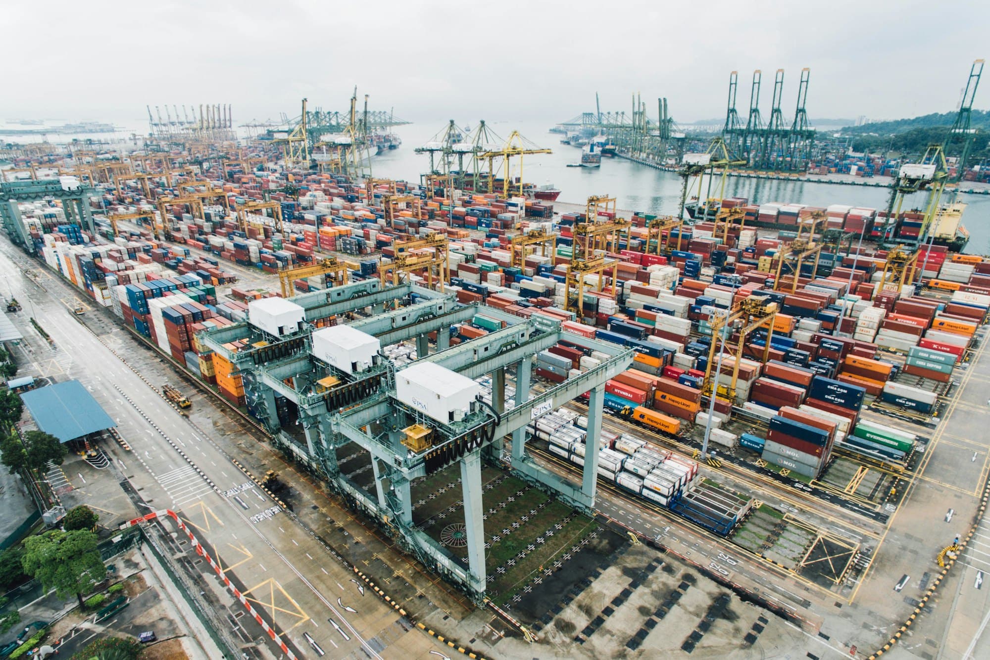 Aerial view of a container terminal with gantry cranes loading cargo ships