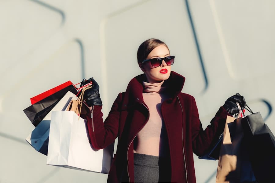 Shopper carrying several paper shopping bags in bright daylight
